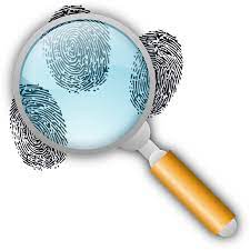 A magnifying glass focusing on black fingerprints, with several fingerprints visible in the background.